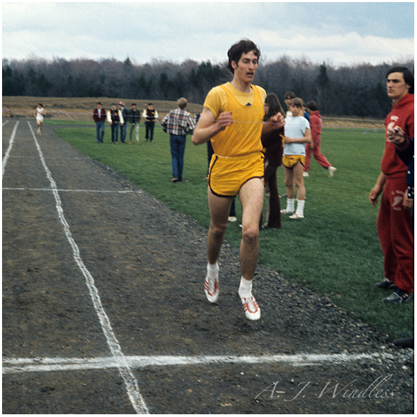 A. J. Windless wins the mile easily, jogging across the finish line and conserving energy for the 800.