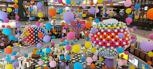A myriad of colorful ballons float above the Promenade court.