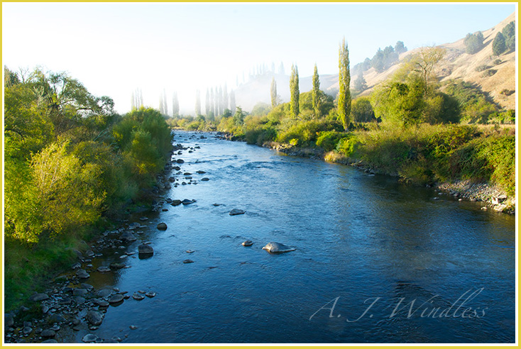 Fog drifts across this New Zealand river.