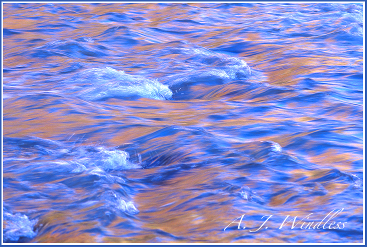 Reflections on the river of red rock walls blended and mixed with reflections of the blue sky.