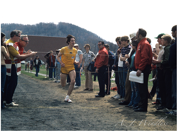 A photo of A. J. Windless crossing the finish line in the mile run.